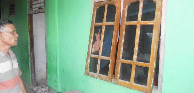Seorang warga Mangga Dua, Reo sedang menatap kaca jendela rumahnya yang pecah akibat dilempari batu oleh warga Mata Air (Foto: Floresa/Ardy Abba)
