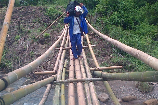 Seorang warga menyeberang di Sungai Wae Laing lewat jembatan bambu (Foto: Ardy Abba/Floresa)