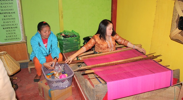 Seorang ibu yang dihadirkan untuk memperlihatkan secara langsung proses pembuatan kain adat Manggarai di stan Dinas Perindakop. (Foto: Evan Lahur/Floresa)