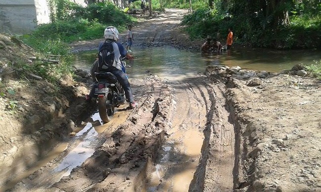 Meski kondisi jalannya berlumpur, warga yang melintas tetap harus membayar (Foto: Ferdinand Ambo/Floresa)